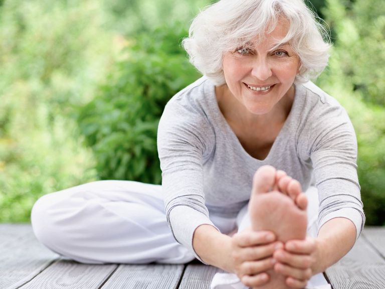 Sportliche Seniorin beim Streching im Freien