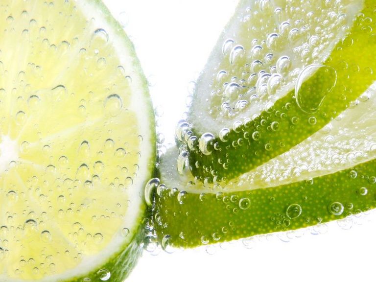 Limettenscheiben schwimmen in sprudelndem Wasser