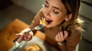 Gesunde Mahlzeiten Frau isst mit einer Gabel ihr Mittagessen
