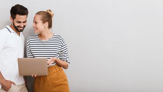 Die ePA für alle Mann und Frau stehen vor einer grauen Wand und schauen lächend auf einen Laptop-Bildschirm