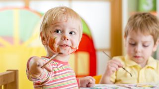 Zwei Kleinkinder malen mit Pinsel und Farbe