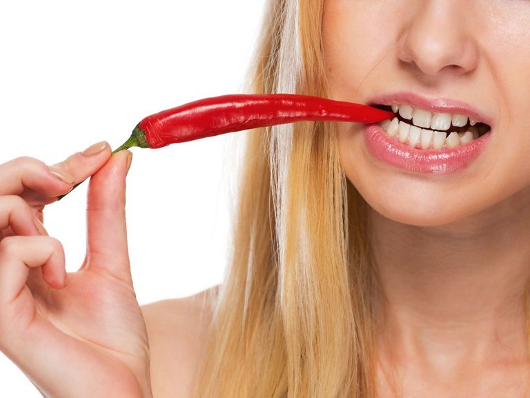 Frau isst eine Chilishote