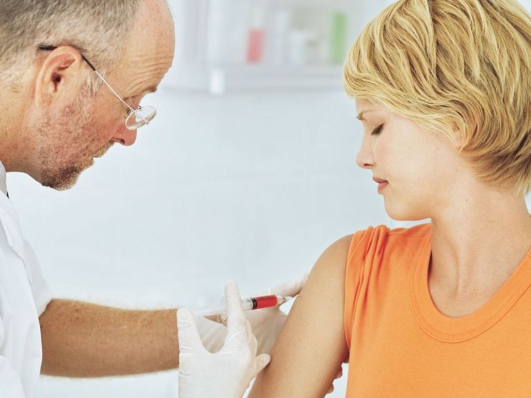 Frau erhält vom Arzt eine Impfung