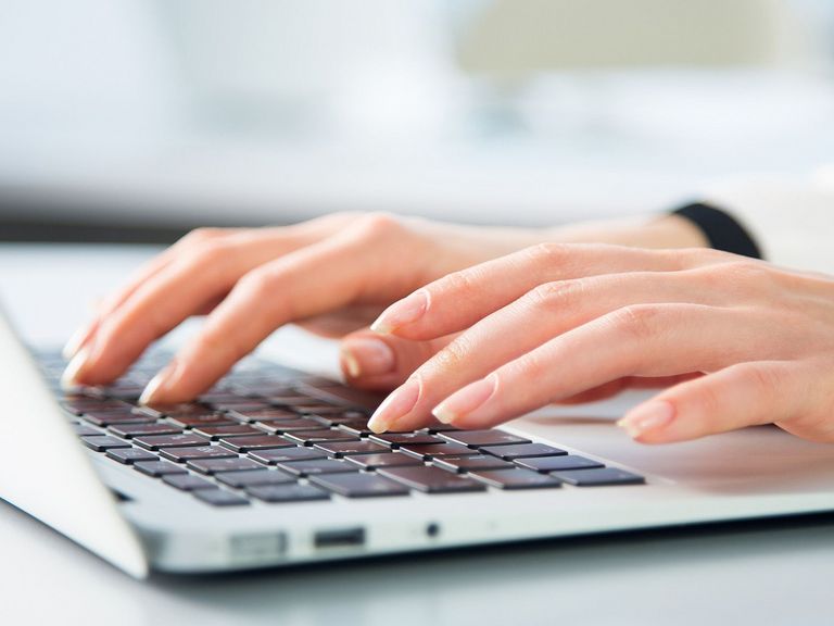 Frau schreibt auf einem Laptop