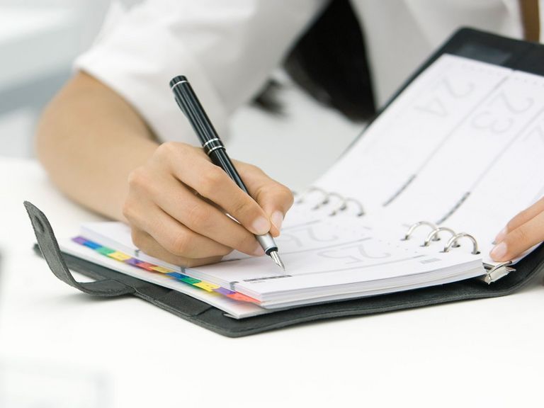 Frau notiert Arzttermin im Kalender