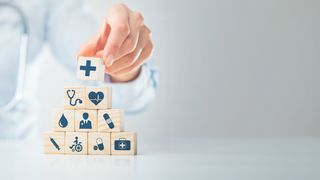 Die elektr. Patientenakte Würfelpyramide mit Symbolen aus dem Gesundheitswesen und einer Ärztin mit Stethoskop im Hintergrund