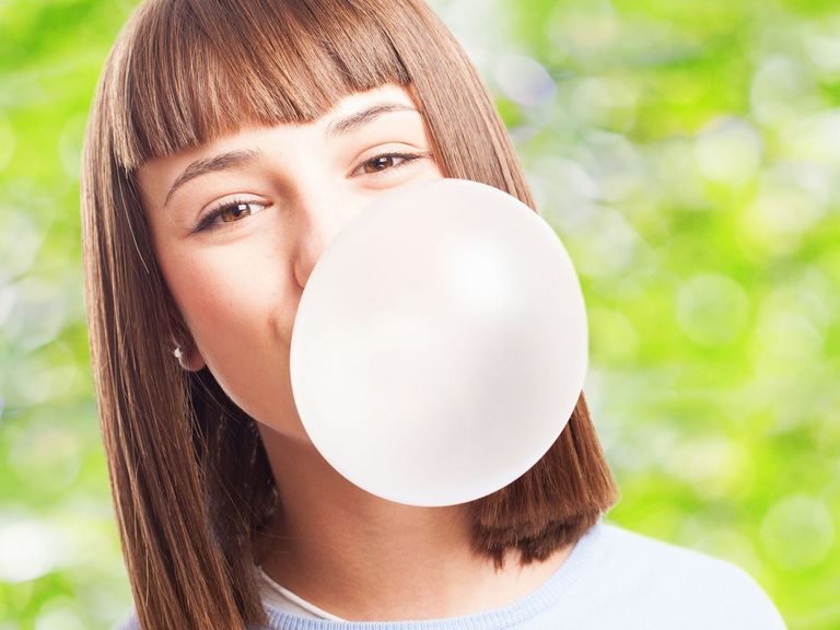 Junge Frau macht eine Kaugummiblase
