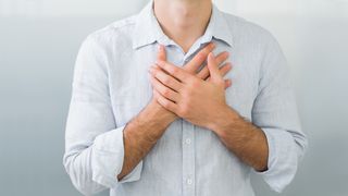 Atemwegserkrankungen Asthma & Bronchitis Mann hat Atemwegserkrankungen und hält sich die Hände vor die Brust