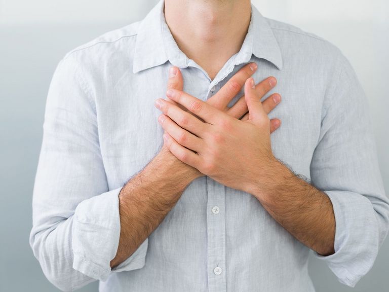 Mann hat Atemwegserkrankungen und hält sich die Hände vor die Brust