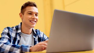 Schulabsolvent vor einem Laptop sitzend