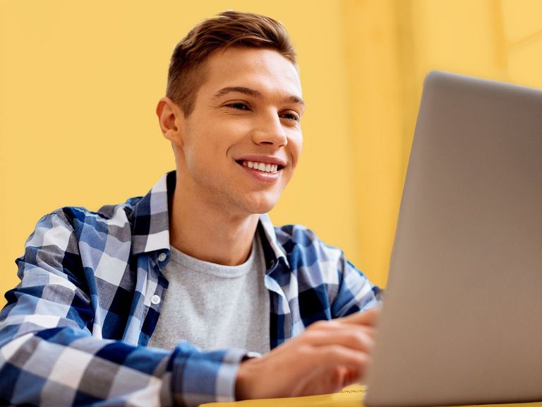 Schulabsolvent vor einem Laptop sitzend
