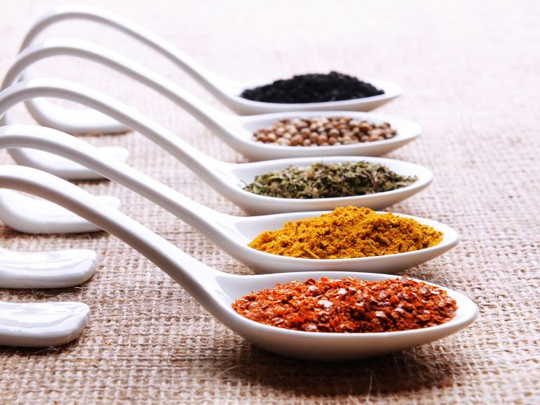 verschiedene Gewürze auf modernen Löffeln