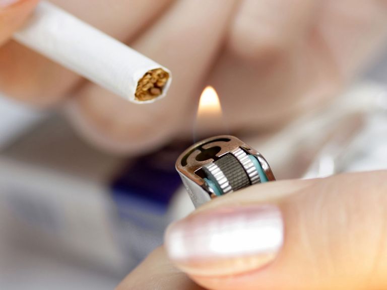 Raucherin zündet sich eine Zigarette an