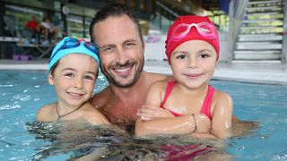 Vater mit Sohn und Tochter im Hallenbad