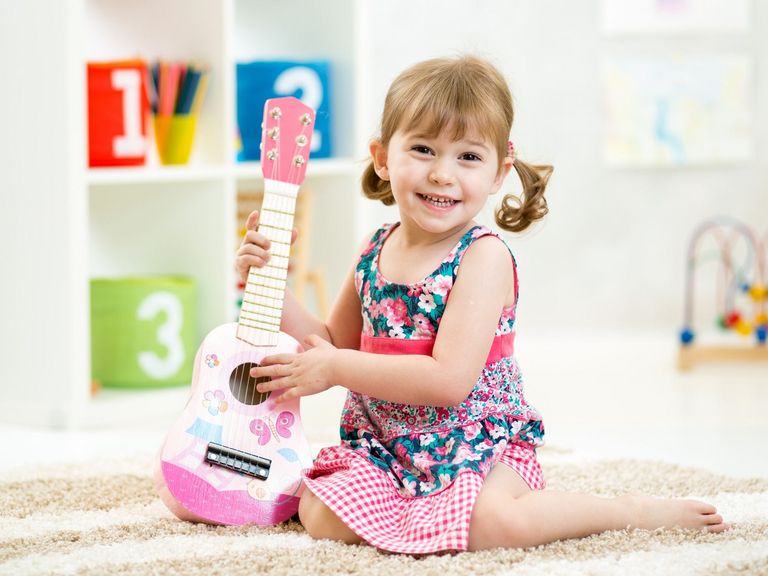 Kleines Mädchen übt auf einer Gitarre