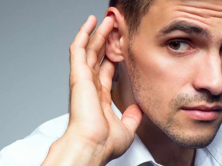 Mann hält sich seine Hand ans Ohr