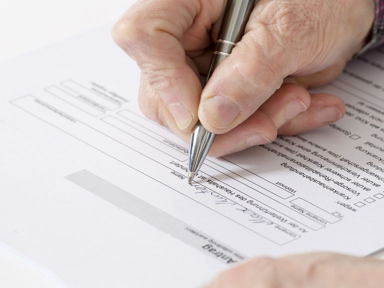 Alte Frau füllt Antrag auf Haushaltshilfe aus