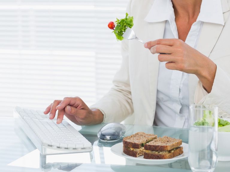 Frau ist am Arbeitsplatz einen Salat