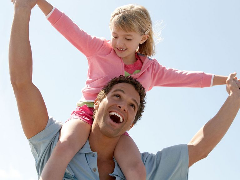 Vater trägt Tochter auf seinen Schultern