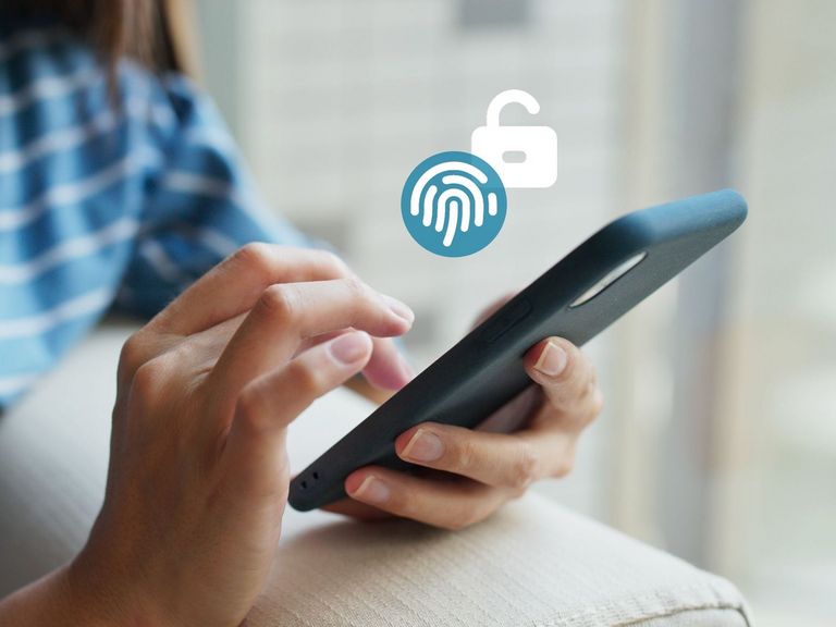 Frau sitzt auf einem Sofa und tippt etwas auf ihrem Smartphone ein