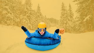 Junge mit gelbem Helm auf einem blauen Airboard