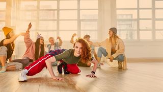 Junge Tänzerin praktiziert Breaking-Bewegungen auf dem Boden, modern dance elements
