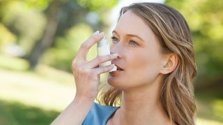 Frau nutzt ein Asthma-Spray