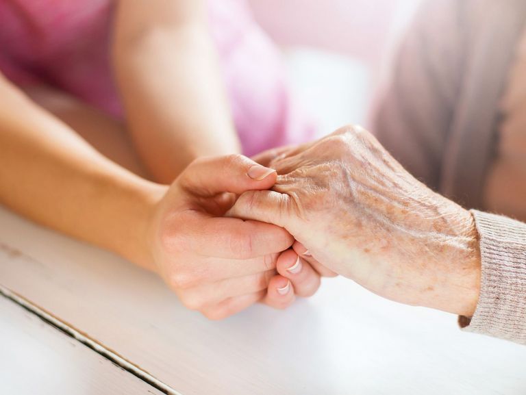 Junge Frau hält die Hand einer älteren Frau