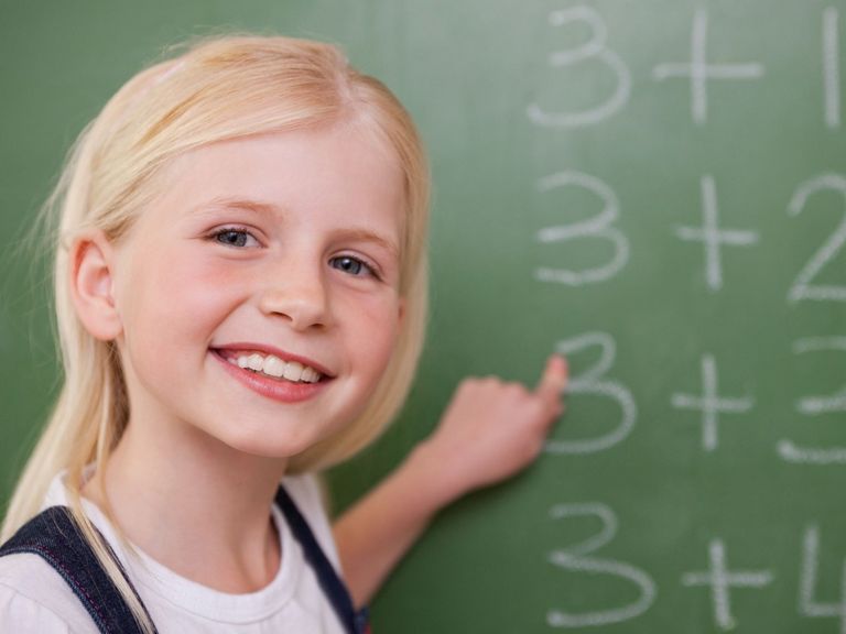 Schulmädchen steht an einer Tafel