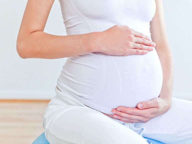 Frau umfasst ihren Babybauch