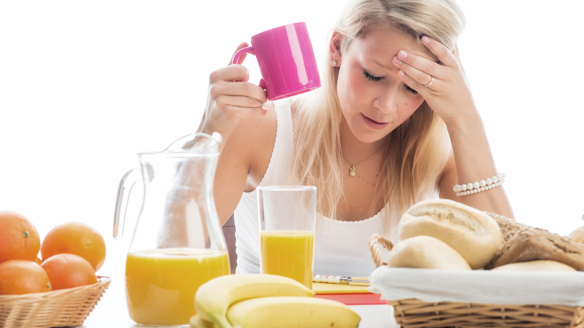 Junge Frau am Frühstückstisch fühlt sich nicht gut