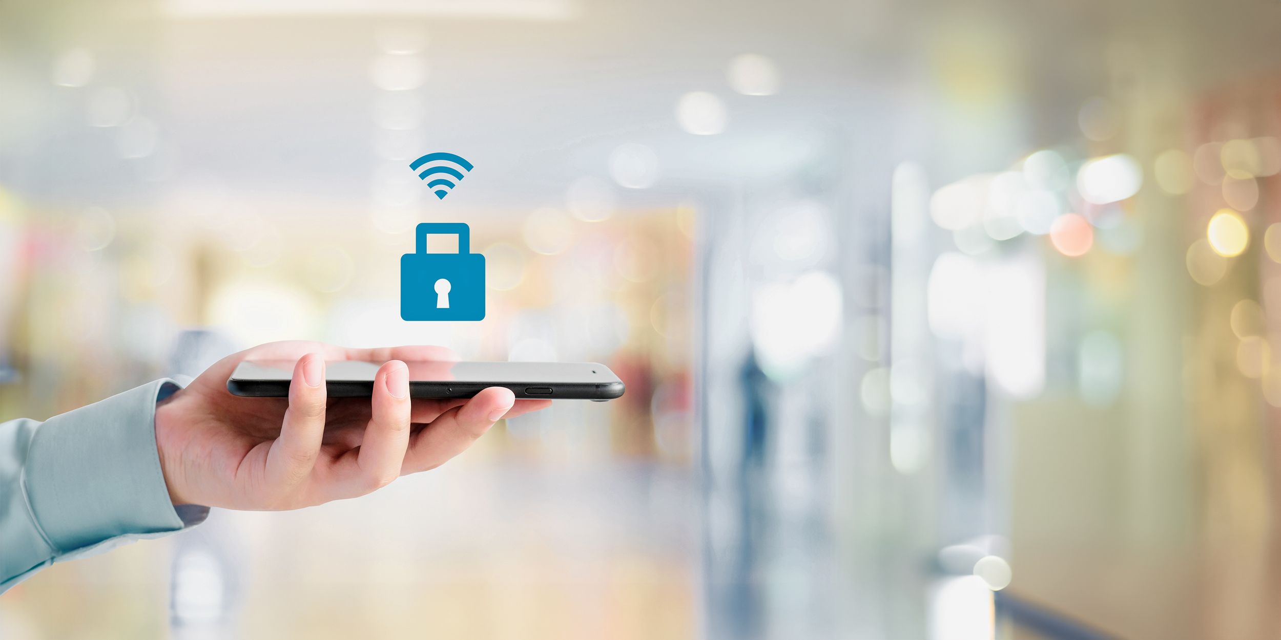 In einer Hand liegt ein Smartphone und darüber schwebt ein Sicherheitsschlosssymbol