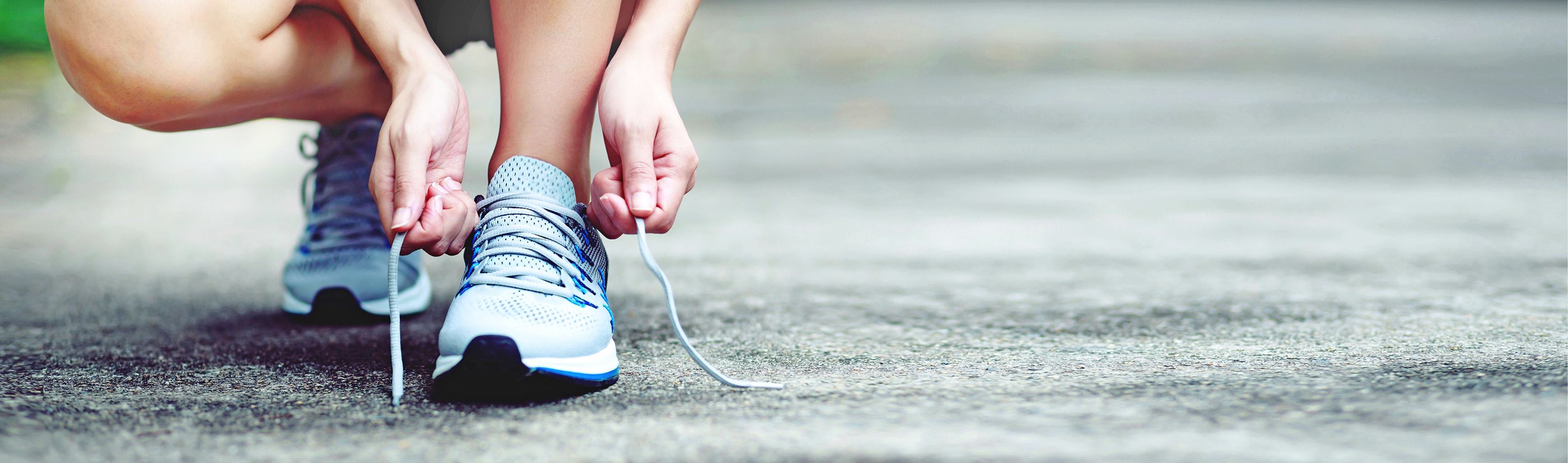 Läuferin bindet die Schnürsenkel ihrer Laufschuhe zu