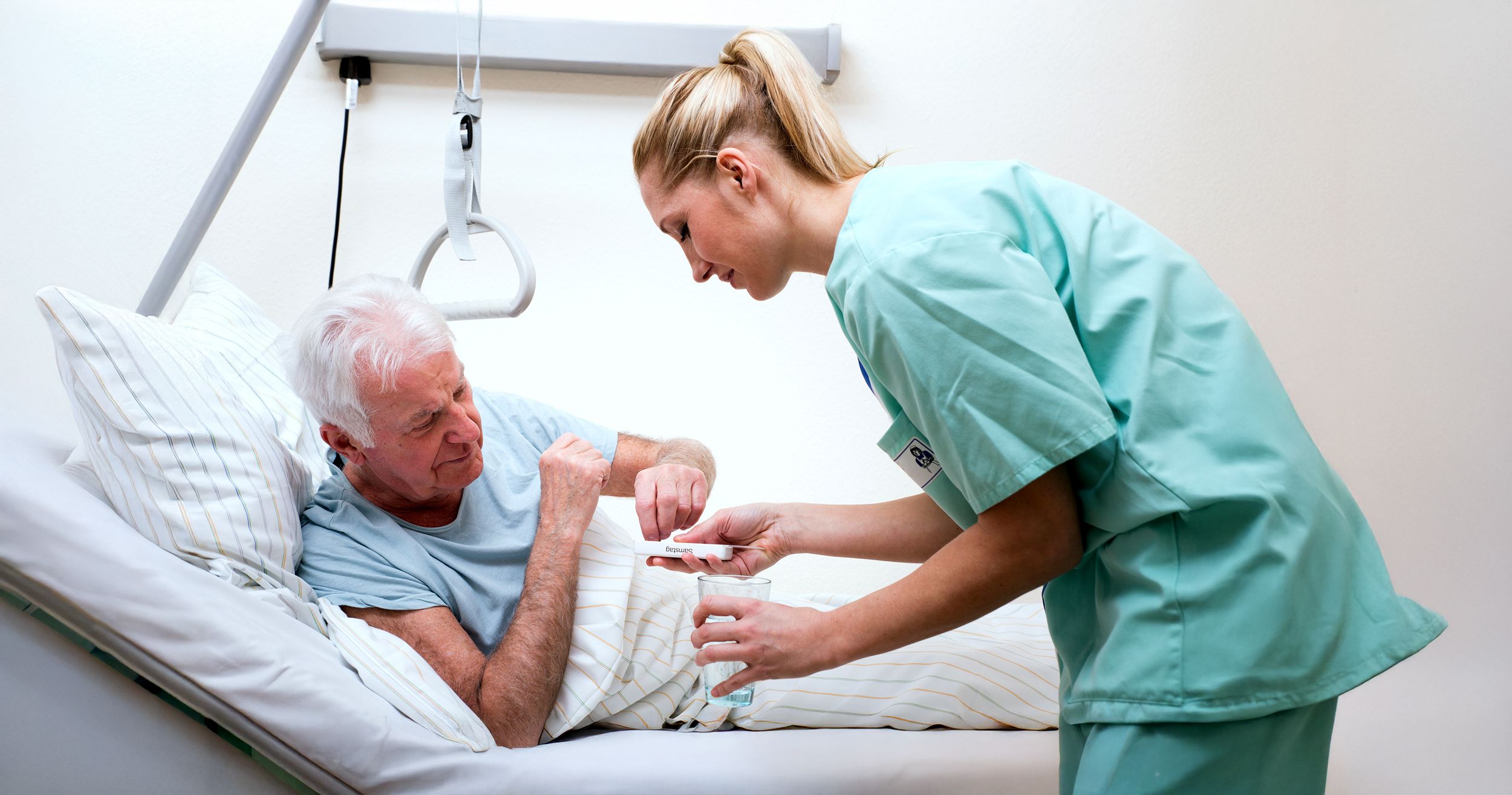 Krankenschwester versorgt einen Pflegebedürftigen mit seinen Medikamenten