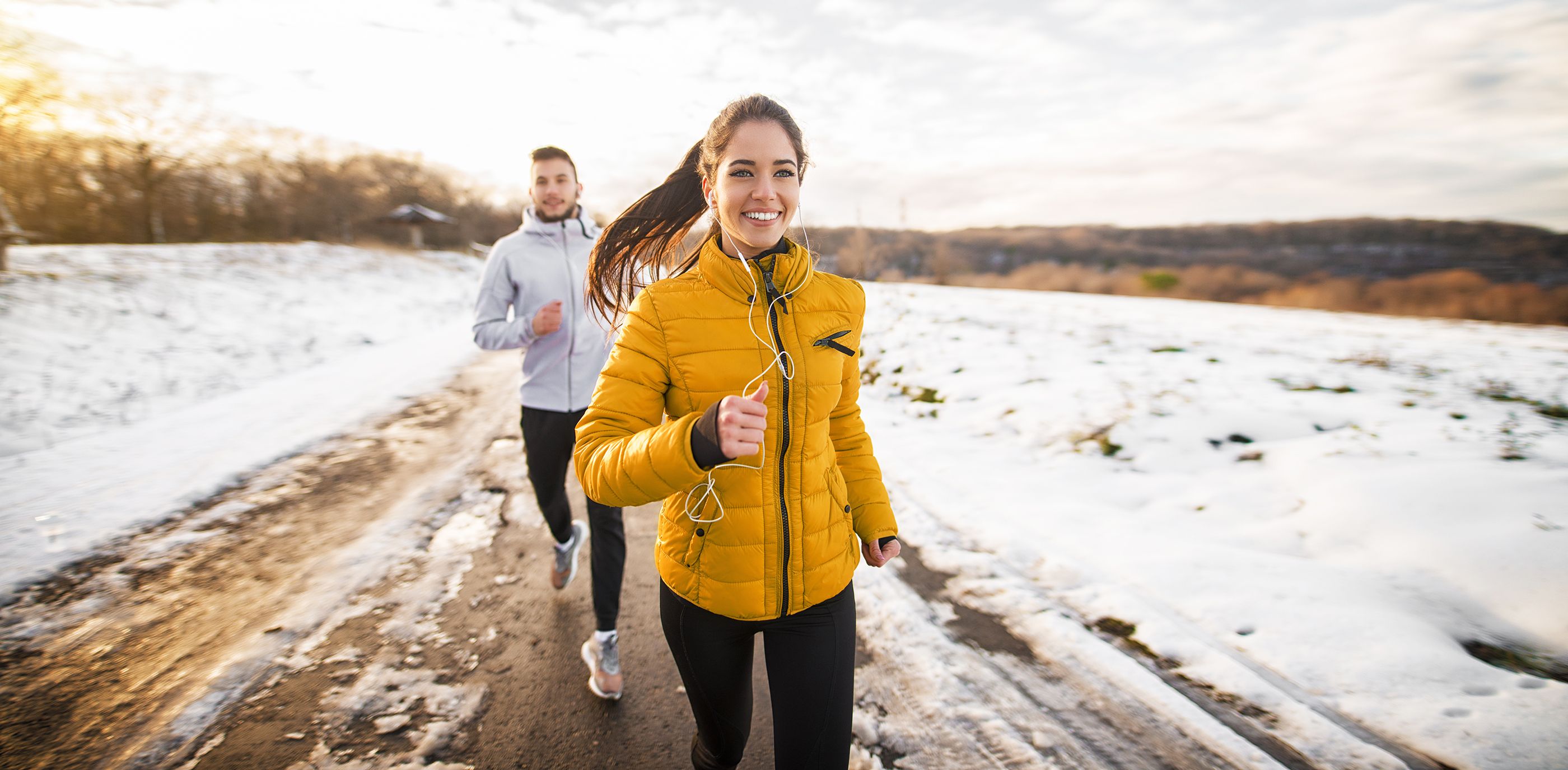 Pärchen in winterlicher Laufkleidung beim Joggen