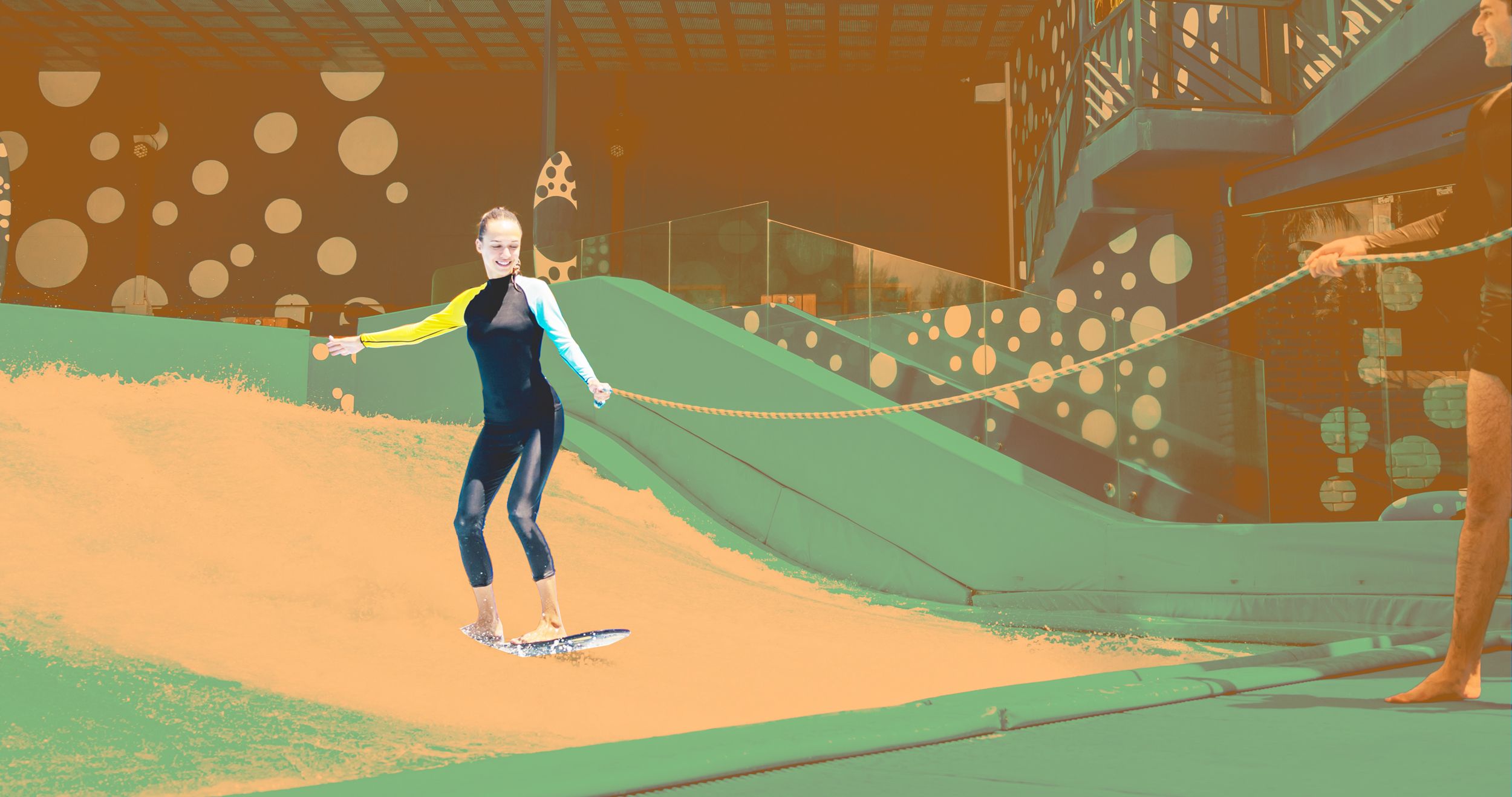 Junge Frau übt das Indoor Surfen mit Sicherungsleine