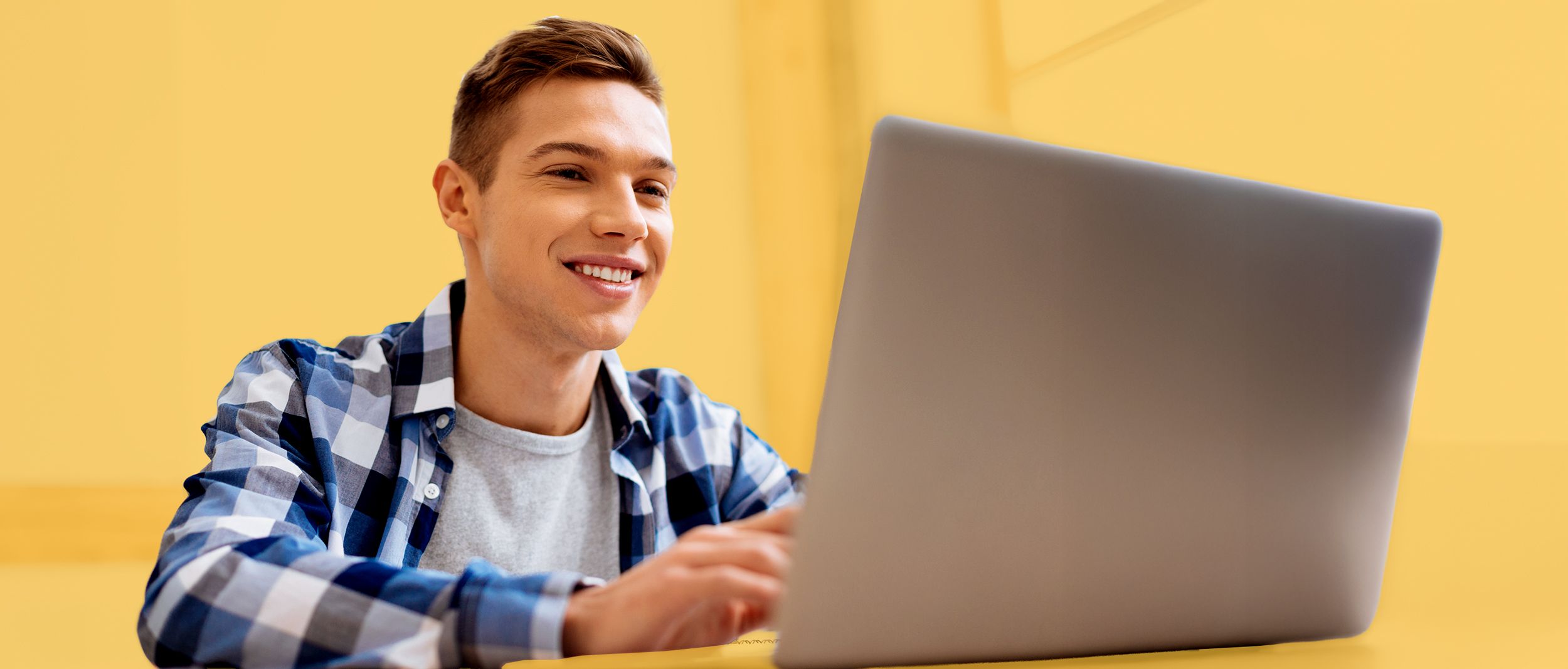 Schulabsolvent vor einem Laptop sitzend
