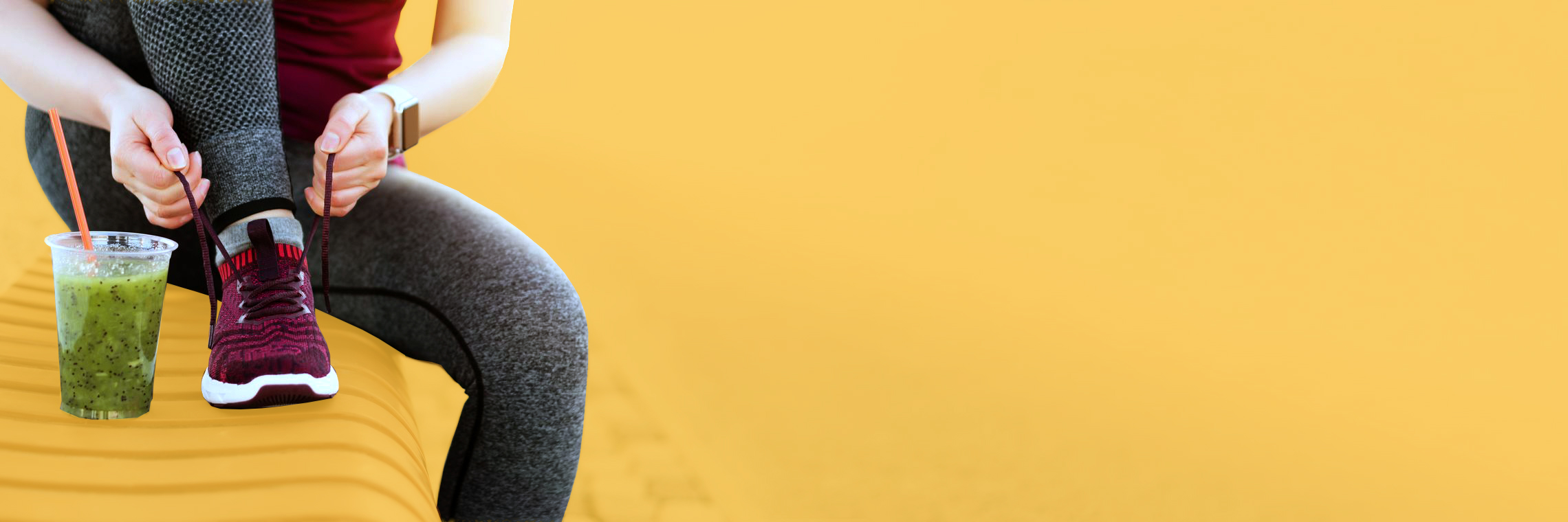 Sportlerin bindet sich auf einer Bank die Schuhe zu