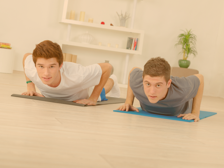Zwei Jungs auf ihren Yoga-Matten in der Kobra-Pose